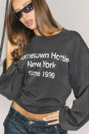 Washed black loose-fit crew neck top with wide long sleeves and text print, front view on model