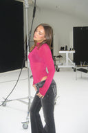 Berry boost (pink) sheer tight-fit turtleneck body with long sleeves, styled with black flared jeans, in a photo studio