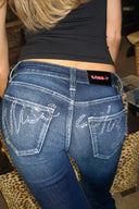 Dark blue bootcut jeans, close-up of the rhinestone Miss Y logo on the back pockets and waistband label