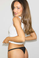 Black lace thong with rhinestone-embellished side straps and minimal back coverage, back view on model
