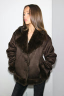 Brown faux fur loose-fit jacket with fur collar and button front, front view on model, hands in pockets