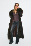 Dark brown faux fur full-length coat worn open with shaggy collar and front trim, front view on model