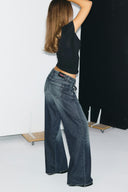 Vintage blue baggy jeans with Miss Y back label and raw-edge hems, side view on model