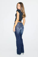 Dark blue low-waist bootcut jeans with rhinestone Miss Y logo on the back pockets, full-length back view on model