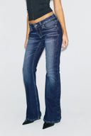 Dark blue loose-fit low-waist bootcut jeans with faded wash, front view on model
