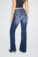 Dark blue low-waist bootcut jeans with sparkly Miss Y script on the back pockets, back view on model