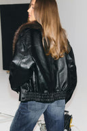 Black faux leather baggy jacket with elasticated waist and long sleeves, back view on model