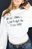 Off-white crew neck top, close-up of the washed text print on the front