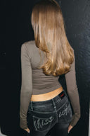 Grey tight-fit drapey top with long sleeves and cropped hem, back view on model