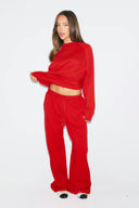 Red loose-fit low-waist sweatpants with wide full-length legs and drawstring, front view on model