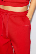 Red sweatpants, close-up of the drawstring waist, side pocket and tonal Miss Y logo on the leg
