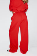 Red loose-fit low-waist sweatpants with wide full-length legs, back view on model