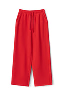 Red wide-leg sweatpants with elastic drawstring waist and side pockets, product shot, front