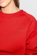 Red crew neck sweater with tonal Miss Y logo on the chest, close-up of neckline and logo