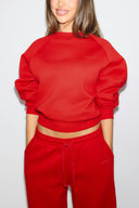 Red baggy crew neck sweater with tonal Miss Y logo and ribbed cuffs, front view on model