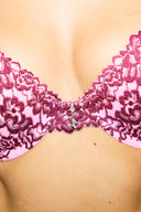 Pink and burgundy lace push-up bra, close-up of the pendant at the centre front