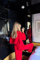 Red baggy crew neck sweater with long sleeves, styled with matching red sweatpants in a mirrored hotel room