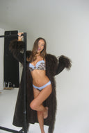 Leopard print satin push-up bra with light blue lace trim, styled with a long shaggy coat in a photo studio