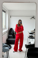 Red loose-fit low-waist sweatpants with wide legs and drawstring, styled with a matching sweatshirt in a mirror selfie