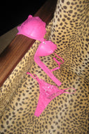 Raspberry rose (pink) lace push-up bra with satin bow, laid out with matching lace thong on a leopard throw