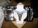 Leopard print satin thong with light blue lace trim, laid on a plate on a room service tray
