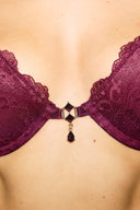 Burgundy lace push-up bra, close-up of jewelled front charm between the lace cups
