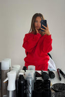 Red baggy crew neck sweater with long sleeves, mirror selfie with matching red sweatpants backstage