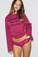 Raspberry rose (deep pink) multitone lace low-waist hipsters with scalloped edges, front view on model with a pink sweatshirt