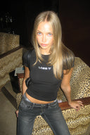 Black tight-fit baby tee with silver Miss Y logo and short sleeves, styled with grey jeans, in a leopard armchair