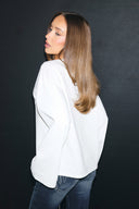 Off-white loose-fit top with wide long sleeves and a plain back, back view on model